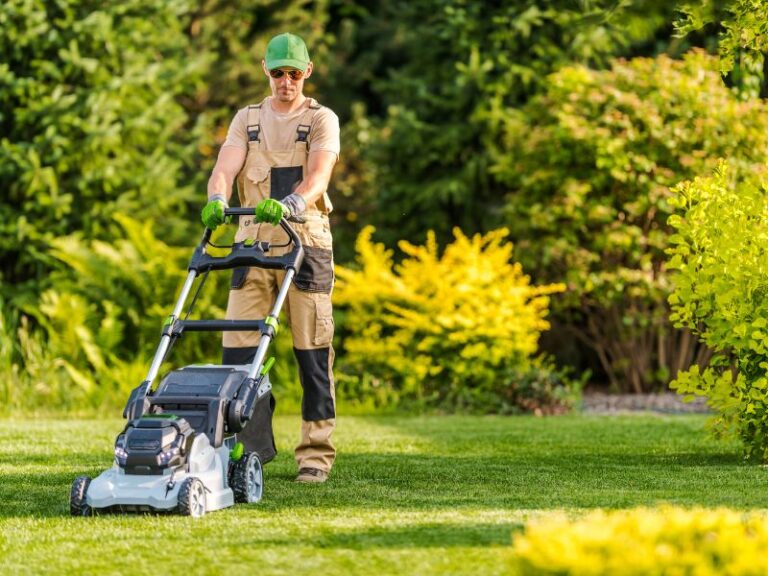 man pushing electric lawn mower